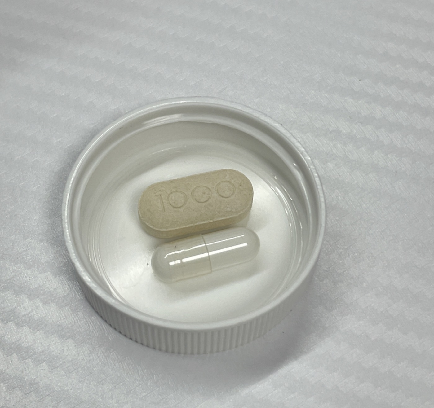 Comparación de tamaño entre la cápsula de Thorne Glutathione-SR y un comprimido de vitamina C de 1.000 mg